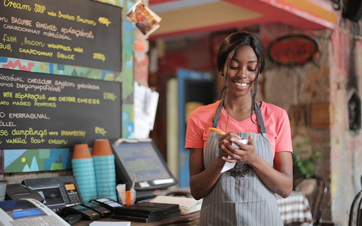 عشق در کسب و کار؛ زنی که با لبخند در حال گرفتن سفارش مشتری است