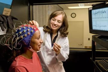 متخصص در حال نصب الکترودهای نوروتراپی بر روی سر بیمار