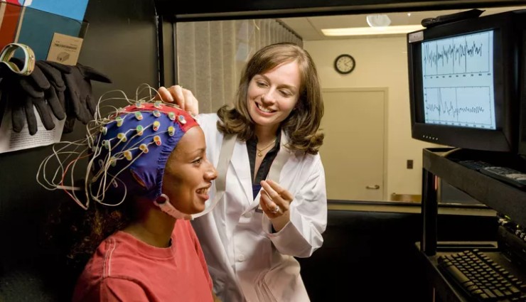 متخصص در حال نصب الکترودهای نوروتراپی بر روی سر بیمار