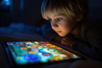 نگاه کودک به صفحه تبلت در تاریکی
