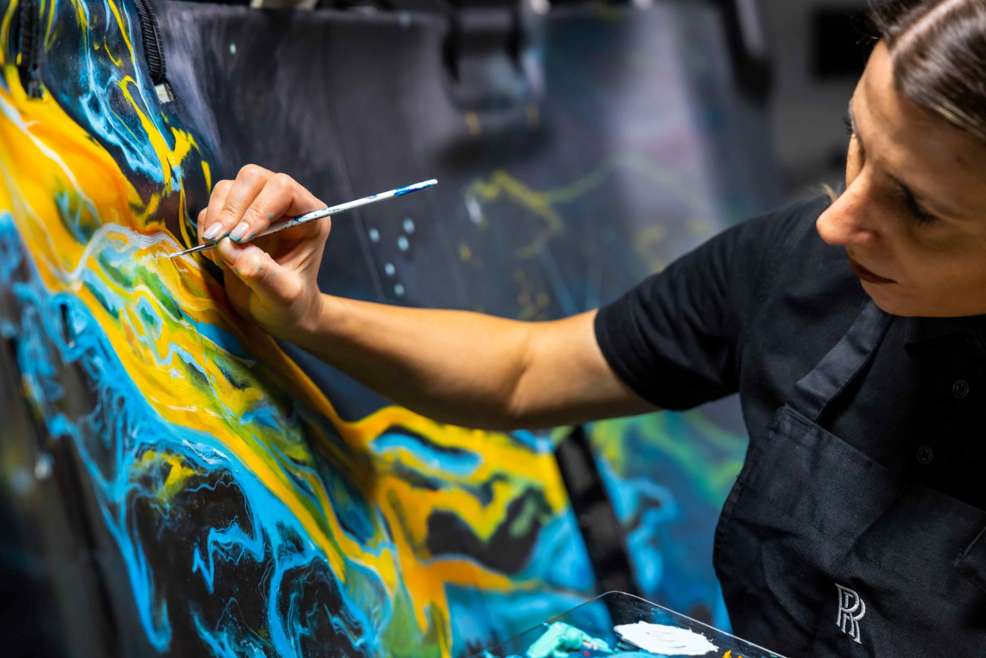 یک نفر در حال نقاشی روی سقف خودرو رولزرویس کالینان کازموس